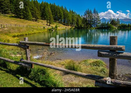 Holzzaun rund um den See von Joux in Vens, Val Aoste, Italien Stockfoto