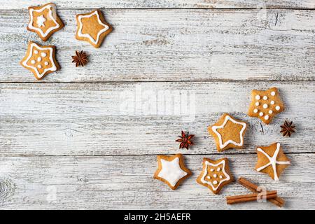 Ecke der Weihnachts Lebkuchen in Form eines Sterns mit Mustern aus Glasur und Gewürzen auf einem weißen Holzhintergrund. Draufsicht mit Kopierbereich Stockfoto