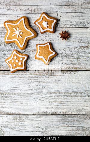 Ecke der Weihnachts Lebkuchen in Form eines Sterns mit Mustern aus Glasur und Gewürzen auf einem weißen Holzhintergrund. Draufsicht mit Kopierbereich Stockfoto