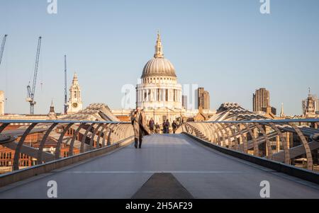 Wahrzeichen Londons. Lange Belichtungszeit von Pendlern, die am frühen Morgen die Themse auf der Millennium Bridge mit der St. Paul's Cathedral überqueren. Stockfoto