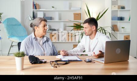 Der Kardiologe liest den EKG-Ausdruck. Der Arzt analysiert das Elektrokardiogramm. Der Arzt untersucht die Ergebnisse des Patienten-S-Tests. Stockfoto