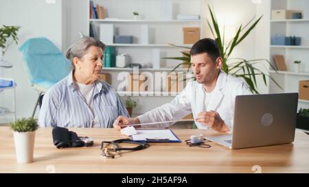 Der Kardiologe liest den EKG-Ausdruck. Der Arzt analysiert das Elektrokardiogramm. Der Arzt untersucht die Ergebnisse des Patienten-S-Tests. Stockfoto