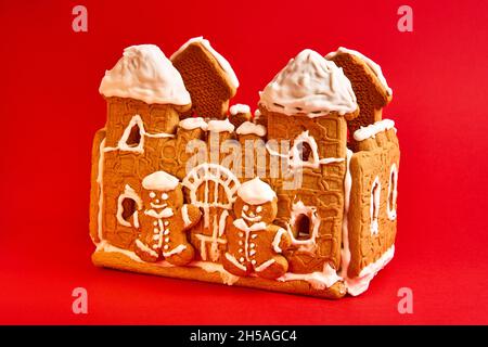 Lebkuchenhaus mit Puderdekor auf rotem Hintergrund Stockfoto