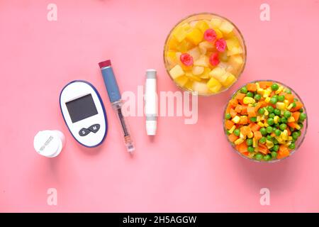Werkzeuge zur Messung von Diabetes und Insulin-Stift und gesunde Ernährung auf Pink Stockfoto