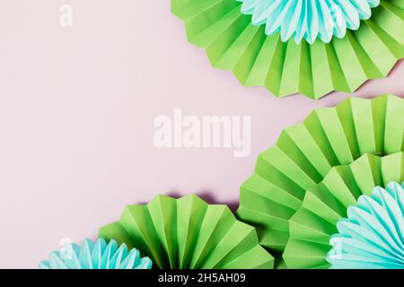 Festlicher Hintergrund mit grünen und blauen Papierventilatoren, Kopierbereich Stockfoto