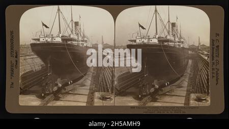 Stereoskopisches Vintage-Foto vom 1903 des Passagierschiffes SS Corinthic im Trockendock zur Wartung in der Stadt Liverpool in England. Gebaut von Harland und Wolff in Belfast wurde sie 1902 für die britischen Reedereien White Star Line und Shaw, Savill & Albion Line ins Leben gerufen. Sie arbeitete als kombiniertes Fracht- und Passagierflugzeug von Liverpool nach Neuseeland. Die SS Corinthic wurde 1931 verschrottet Stockfoto