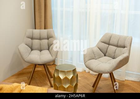 Stilvolle, weiche graue Sessel in moderner Designer-Einrichtung. Weicher, selektiver Fokus. Stockfoto