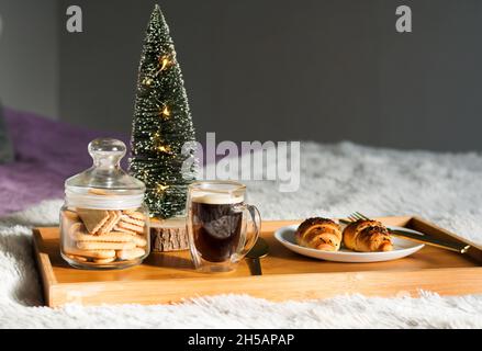 Frühstückspension mit Kaffeetasse, Croissants und Kekse auf Tablett. Weihnachtsmorgen Stockfoto