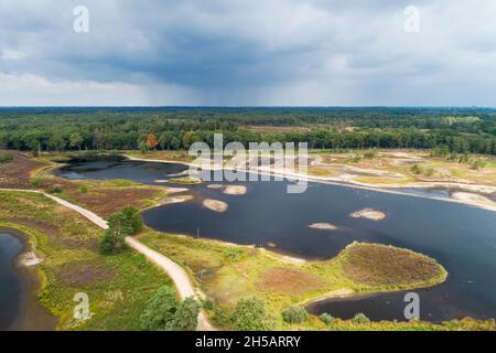 Luftaufnahme von teilweise ausgetrockneten Fennen im Overasseltse en Hatertse Vennen mit einer Regendusche am Horizont während des extrem d Stockfoto