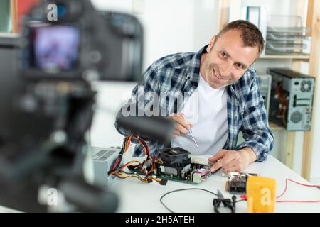 Der Vlogger, der Computer-Reparatur auf Kamera für vlog Blog aufzeichnet Stockfoto