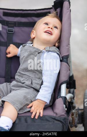 Entzückender Baby Junge trägt in einem Kinderwagen Stockfoto