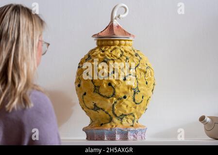 London, Großbritannien. 8. November 2021. Eine Frau betrachtet 'Lidded Jar', von Richard Slee, um 1984, (Est. £2,000-3,000) in der Vorschau auf eine Sammlung von Museum Qualität Studio zeitgenössische Keramik des verstorbenen Dr. John P Driscoll. Die Sammlung von über 160 Werken wird voraussichtlich am 10. November im Phillips in Berkeley Square für 2 Mio. £in einer Auktion mit dem Titel The Art of Fire verkauft. Kredit: Stephen Chung / Alamy Live Nachrichten Stockfoto