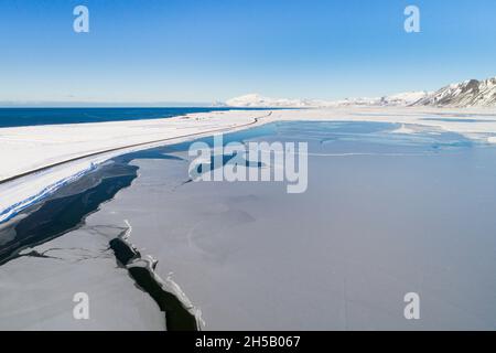 Luftaufnahme im Winter eines gefrorenen Sees entlang der Südküste von Snaefellsnes, Vesturland, Island Stockfoto