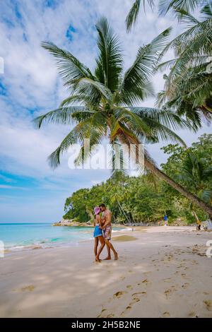 Surin Strand in Phuket, südlich von Thailand, berühmtes Touristenziel in Phuket, schöner Strand, Blick auf einen schönen tropischen Strand mit Palmen um. Paar Mann und Frau am Strand Stockfoto