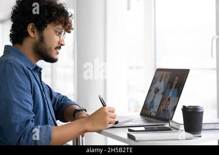 Indischer Mann, der eine App für die Videokommunikation im Fernverkehr mit Kollegen über einen Laptop verwendet Stockfoto