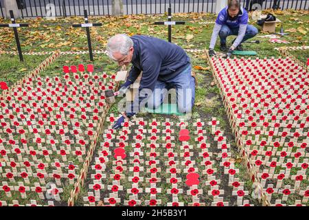 Westminster, London, Großbritannien. November 2021. Freiwillige aus vielen verschiedenen Organisationen, in Zusammenarbeit mit der Royal British Legion, stellen die Ehrungen auf, die in den Feldern des Gedenkens gepflanzt wurden, wobei jeder eine persönliche Botschaft an jemanden trägt, der im Dienst des Landes auf dem Gelände der Westminster Abbey in London sein Leben verloren hat. Kredit: Imageplotter/Alamy Live Nachrichten Stockfoto