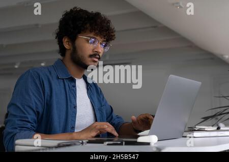 Indischer Mann IT professioneller Freiberufler arbeitet mit Laptop-Computer im Büro Stockfoto