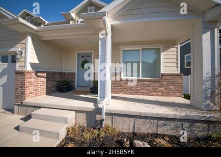 Veranda eines Hauses in der Nähe der Garage mit Vinyl-Holz und Ziegel Abstellgleis Stockfoto