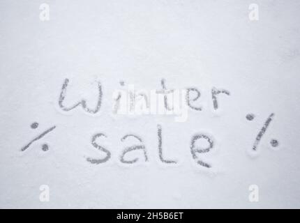 Inschrift Winterverkauf auf weißem Schnee geschrieben. Saisonale Rabatte, Hintergrund für Geschäfte und Geschäfte Stockfoto