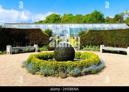 Kugelförmige Skulptur Brunnen und Glashaus im hinteren Teil des Flower Garden, Arundel Castle, West Sussex, Großbritannien Stockfoto