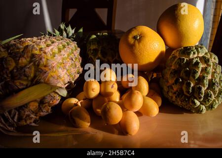 Verschiedene Früchte wie Ananas, malta, Orangen, Puddingäpfel, frische gelbe knusprige Datteln auf dem Esstisch für das Frühstück am Morgen. Esstisch im Innenbereich Stockfoto