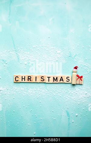 Weihnachtsmann mit dem Text Weihnachten und Geschenkbox mit roter Schleife auf blauem Hintergrund mit Schnee, Frohe Weihnachten, Urlaub, Geschenk-Konzept mit Kopierraum Stockfoto