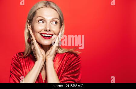 Urlaub und Frauen Beauty-Konzept. Lächelnd schöne Frau 50 Jahre, reife Dame mit perfekter Haut und Lächeln, Blick beiseite glücklich, posiert für Stockfoto