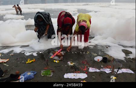 Neu-Delhi, Indien. November 2021. Giftiger Schaum schwimmt auf der Oberfläche des verschmutzten Yamuna-Flusses, während hinduistische Anhänger am Montag, den 8. November 2021, im Rahmen der Rituale des viertägigen „Chhath Puja“-Festivals in Neu Delhi, Indien, ein Bad nehmen. Das alte hinduistische Fest, das dem sonnengott gewidmet ist, wird für das Wohlergehen, die Entwicklung und den Wohlstand der Familienmitglieder gefeiert. Foto von Abhishek/UPI. Kredit: UPI/Alamy Live Nachrichten Stockfoto