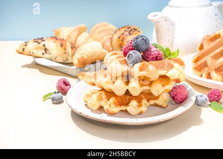 Modernes Dessert-Croffle: Eine Mischung aus Croissants und Waffeln, Waffeleisen-Pfanne mit Waffeleisen, Beerenfrüchten und Schokolade Stockfoto