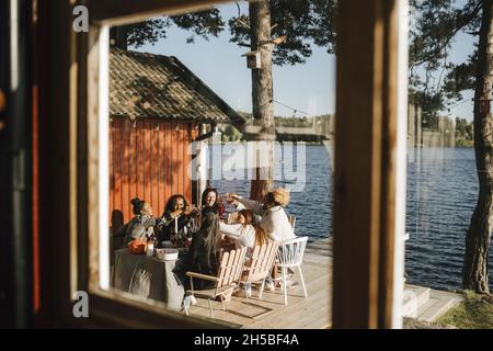 Weibliche Freunde feiern während der Party durch das Fenster gesehen Stockfoto