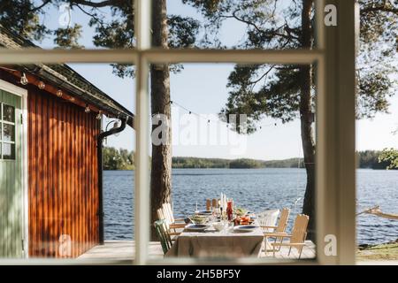 Arrangiert Esstisch durch das Fenster gesehen an sonnigen Tag Stockfoto