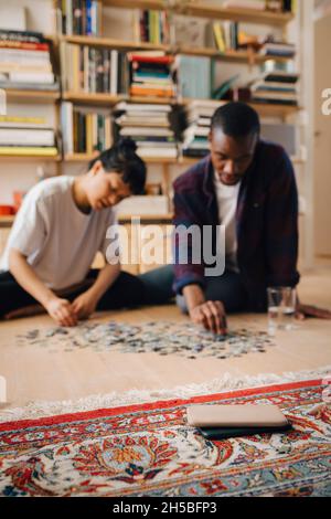 Smartphones auf dem Teppich mit Paar im Hintergrund zu Hause Stockfoto