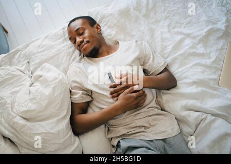 Ein Mann mittleren Erwachsenen, der im Schlafzimmer mit einem Buch auf dem Bett schlief Stockfoto