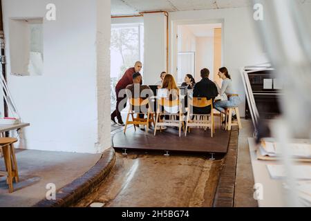 Männliche und weibliche Geschäftsleute, die sich im Büro treffen Stockfoto