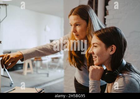 Reifer Hacker, der während der Arbeit im Büro mit einer Kollegin spricht Stockfoto