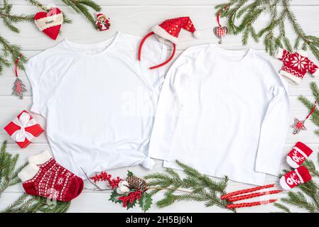 Kinderkleidung mit Weihnachtssymbolen und Dekor auf dem Tisch Stockfoto