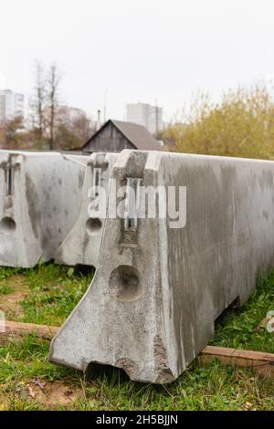 Betonstoßstangen auf einer Baustelle. Hackmaschinen für die Verkehrssicherheit. Stockfoto