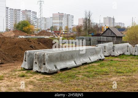 Betonstoßstangen auf einer Baustelle. Hackmaschinen für die Verkehrssicherheit. Stockfoto