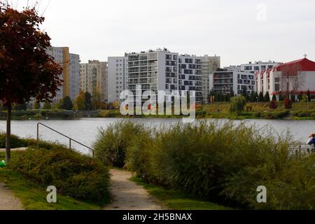 Warschau, Polen - 20. Oktober 2021: Auf der anderen Seite des Sees befinden sich moderne Wohngebäude, in denen viele Familien im Wohnbezirk Goclaw wohnen. Stockfoto