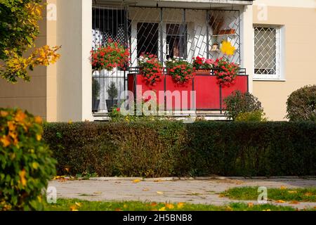 Warschau, Polen - 20. Oktober 2021: In einem großen Wohnblock, in dem viele Familien leben, befindet sich ein Balkon, der zur Wohnung im Erdgeschoss gehört Stockfoto
