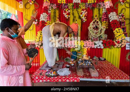 Howrah, Westbengalen, Indien - 29. Juni 2020 : Hindu-Priester verehrt Götzen von Gott Jagannath, Balaram und Suvudra im Pandal mit heiligem Yajna-Feuer. Stockfoto