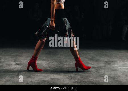 Modelin in roten High Heels Walking Catwalk Modenschau Stockfoto