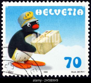 SCHWEIZ - UM 1999: Eine in der Schweiz gedruckte Briefmarke zeigt den Pinguin Pingu als Postmann, Tragetasche, um 1999 Stockfoto