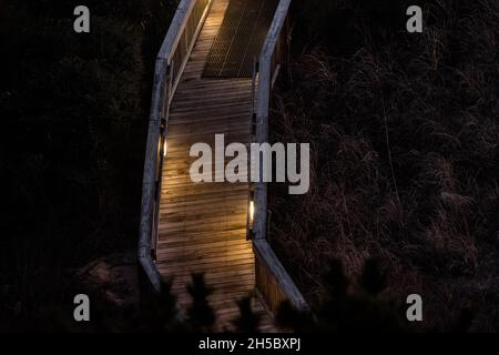 Myrtle Beach in der Nacht Luftaufnahme aus dem hohen Winkel auf Holzboardwalk Strand Zugang Weg durch Sanddünen und beleuchtete Lichter Lampe aus der Nähe Stockfoto