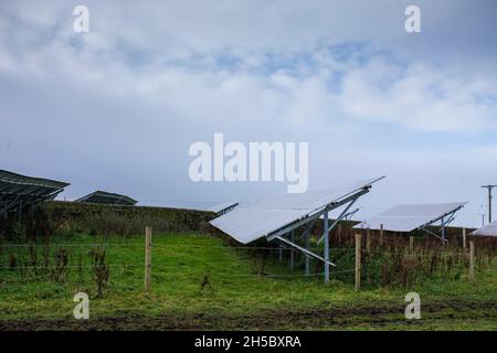 Eine Solarfarm hinter einem kleinen Gewerbepark in der Nähe von Denholme in West Yorkshire, Großbritannien, inmitten von Feldern und Ackerland auf dem Moor hinter dem Gewerbepark. Stockfoto