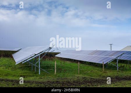 Eine Solarfarm hinter einem kleinen Gewerbepark in der Nähe von Denholme in West Yorkshire, Großbritannien, inmitten von Feldern und Ackerland auf dem Moor hinter dem Gewerbepark. Stockfoto