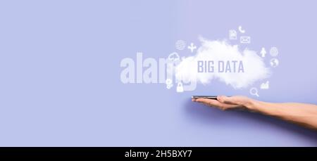 Geschäftsmann hält die Inschrift , Wort BIG DATA . Vorhängeschloss, Gehirn, Mann, Planet, Graph, Lupe, Zahnräder, Symbol für Cloud, Grid, Dokument, Brief, Telefon Stockfoto