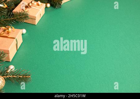 weihnachts-Geschenkboxen mit weihnachts-Accessoires auf grünem Hintergrund. Vorbereitung auf die Feiertage. Draufsicht mit Kopierbereich. Stockfoto