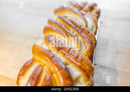 Makro-Nahaufnahme von ganzen Laib hausgemachtem Frischkäse Brioche Brot Dessert, süße französische Gebäck Lebensmittel Mahlzeit auf Holz Küchentisch Stockfoto