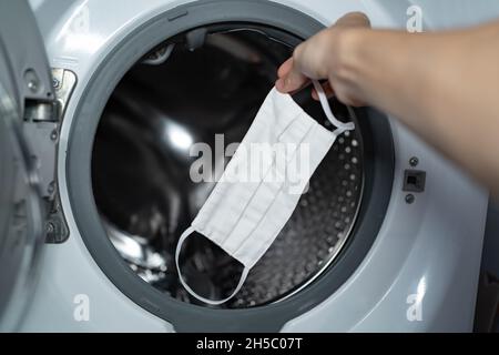 Bringen Sie die Gesichtsmaske aus Stoff in die Waschmaschine Stockfoto